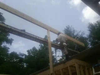 Carpenter setting a ridge beam over a new addition frame — Ice Dam Removal by Roofing Brothers in Andover
